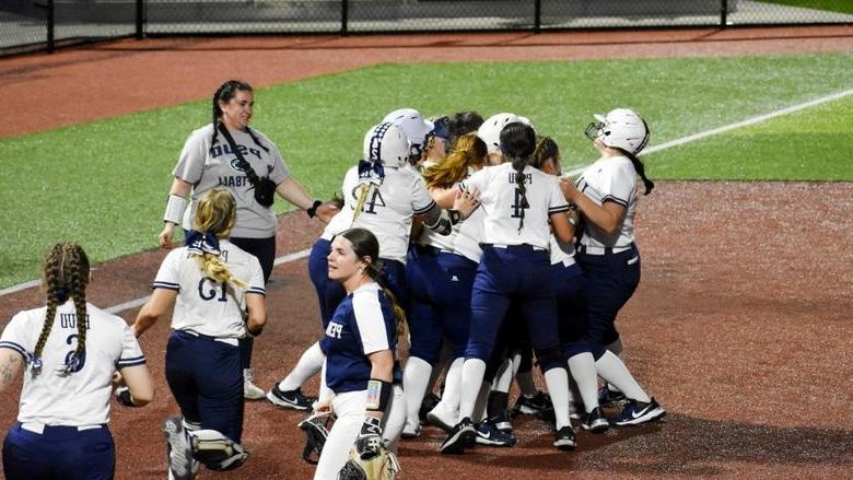 The 365英国上市杜波依斯分校 softball team rush the field to celebrate a walk off win against Penn State Fayette at Heindl Field in 杜波依斯