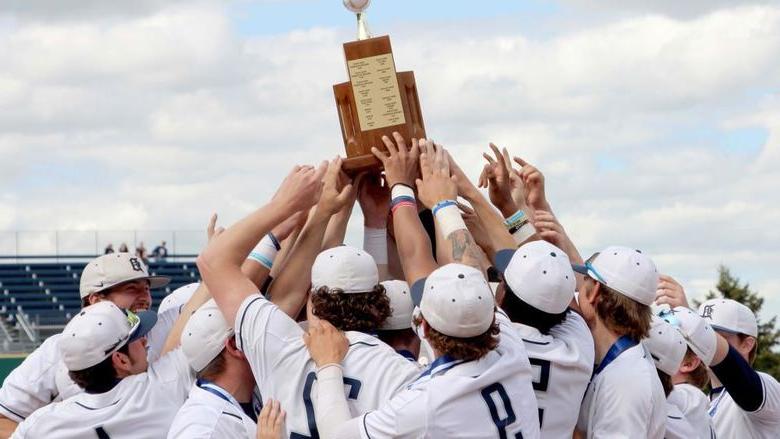 The 365英国上市杜波依斯分校 baseball team lifts the PSUAC championship trophy as a team after winning the championship on Monday
